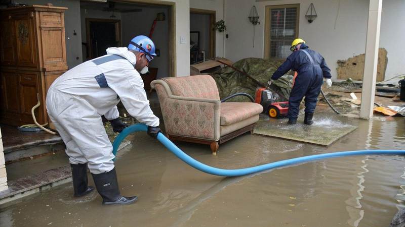 Restoration crew pumping flood water from inside a Texas home