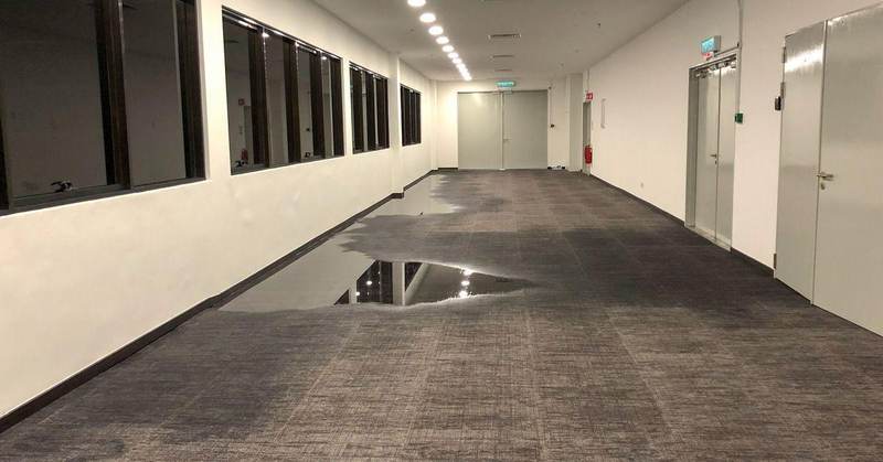 Standing water across a commercial office hallway in Texas after flooding